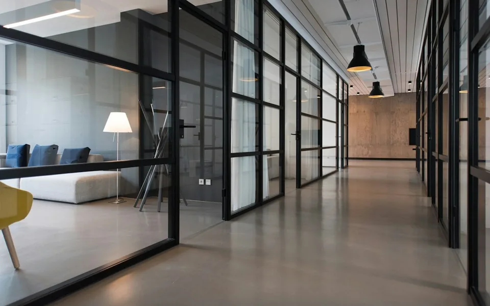 Modern office interior with glass partitions and lounge seating